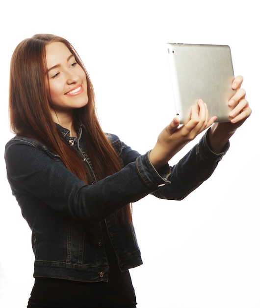 Chica tomando selfie con tableta digital, aislado sobre fondo blanco.