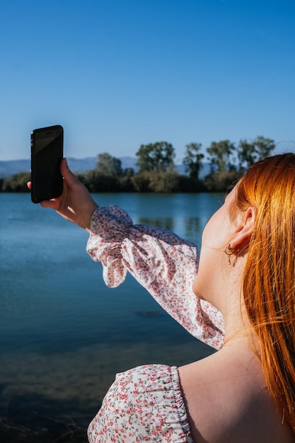 Chica tomándose una selfie frente a un río