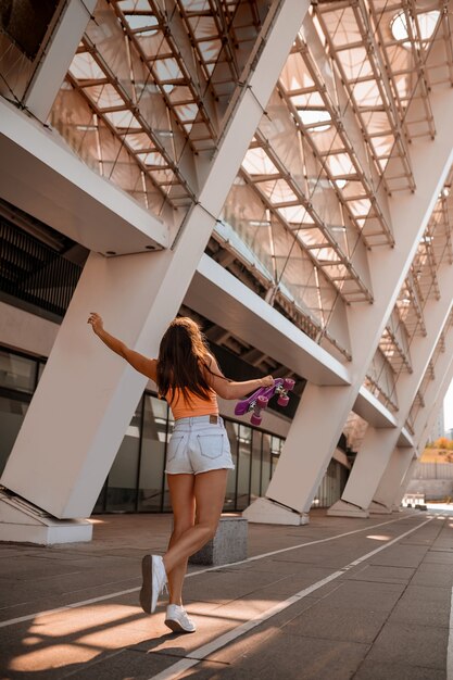 Una chica en top y shorts luciendo feliz y disfrutada.