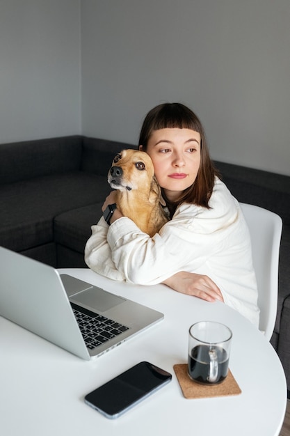 Una chica trabajando en casa con su mascota.