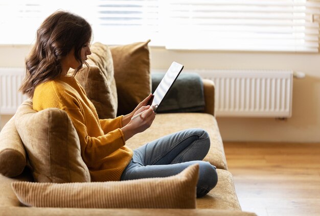 Chica trabajando en casa con una tableta durante la cuarentena