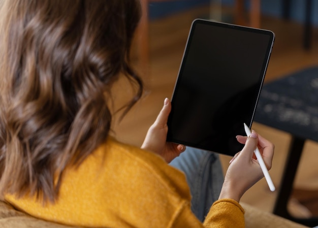 Chica trabajando en casa con una tableta durante la cuarentena