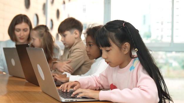 La chica trabajando en la computadora portátil y girar la cabeza para hacer ok o ok en la cámara erudición