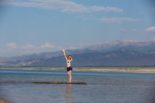 Chica en traje de baño en un lago de montaña