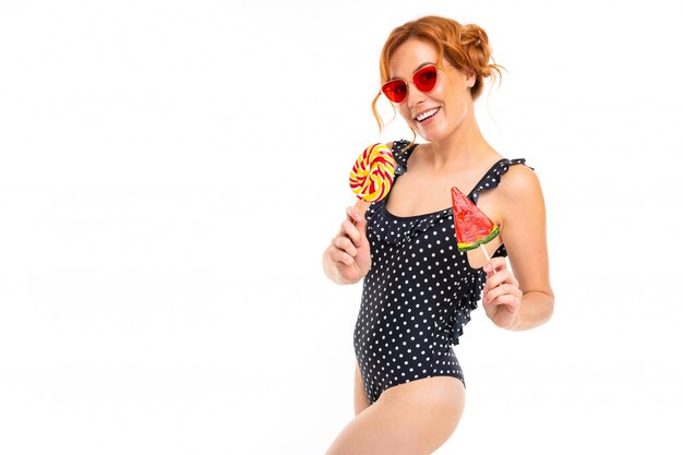 Chica en traje de baño retro con un estampado en blanco y negro con dos piruletas en un blanco