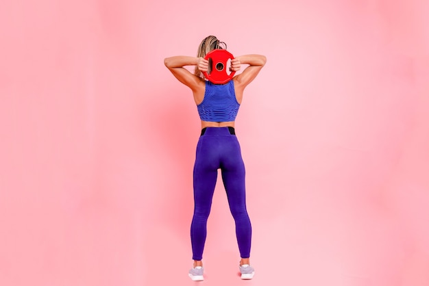 Chica en un traje deportivo azul sobre un fondo rosa de pleno crecimiento