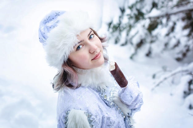 Chica en el traje de la doncella de nieve come paletas.