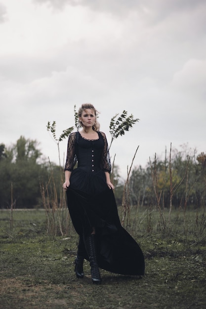 Chica en traje negro en el campo