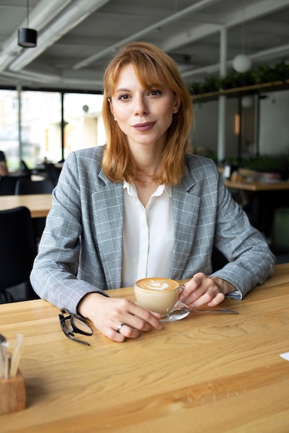 Chica de traje con una taza de café.