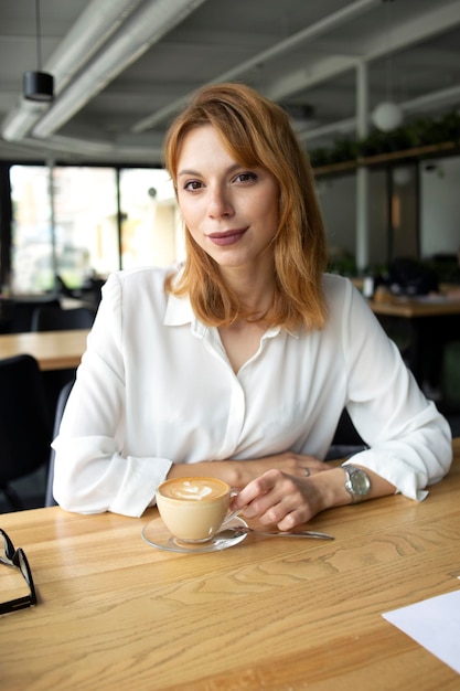 Chica de traje con una taza de café.