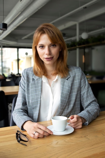 Chica de traje con una taza de café.