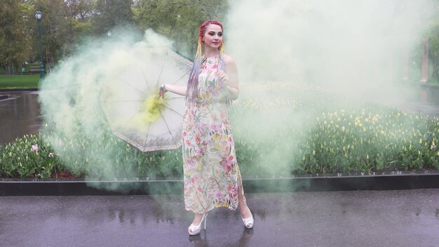 Chica con trenzas africanas y maquillaje en vestido de primavera está bailando