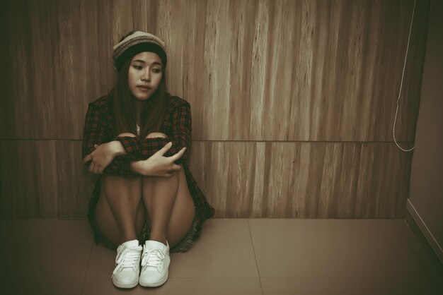 Foto chica triste asiática en la biblioteca estilo vintagemujer tailandesa estrés del concepto de desamor de amortono oscuro