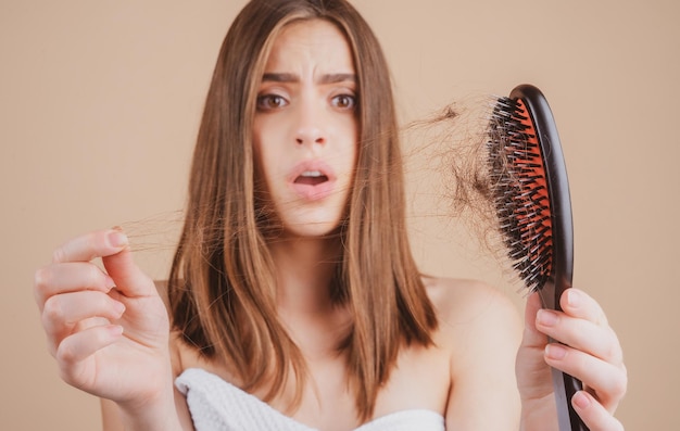 Chica triste mirando el cabello dañado el problema de la pérdida de cabello espacio de copia aislado