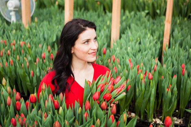 Chica con tulipanes cultivados en un invernadero.