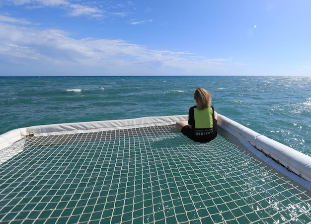 chica en una tumbona mirando al mar