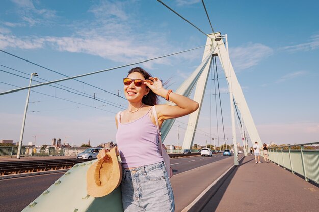 Una chica turista admira la vista del río Rin y la ciudad de Colonia desde el puente colgante de Deutz y el terraplén