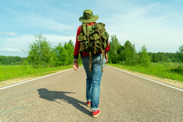 Chica turista en la carretera asfaltada.