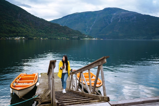 Chica turista en chaqueta amarilla Mujer activa relajándose en Noruega Aventura de estilo de vida itinerante