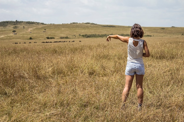 Una chica turista europea disfrutando dentro del parque nacional de Masai Mara, animales en libertad en la sabana. Kenia, Africa