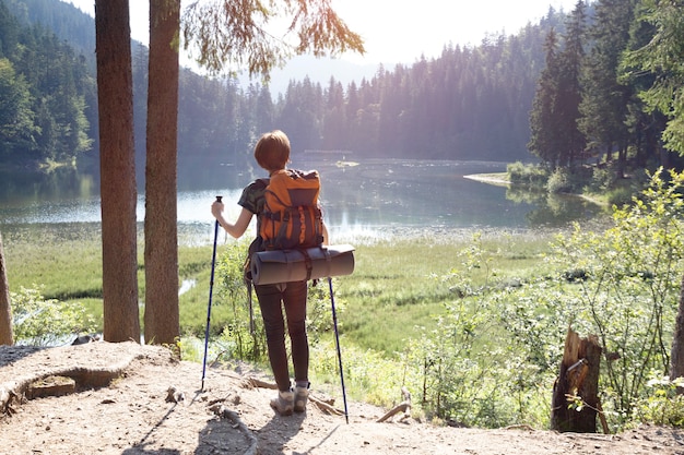 Chica turista en un lago de montaña synevyr en la puesta de sol. Cárpatos, Ucrania.