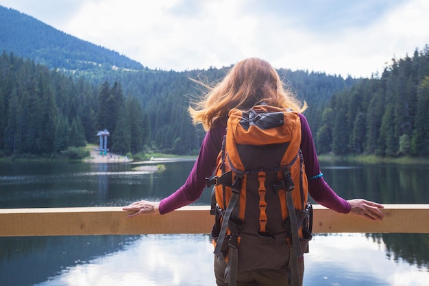 Chica turista en un lago de montaña