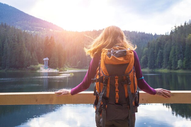 Chica turista en un lago de montaña