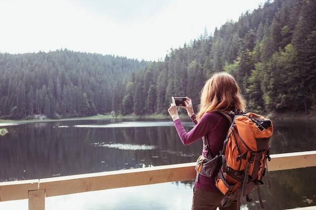 Chica turista en un lago de montaña