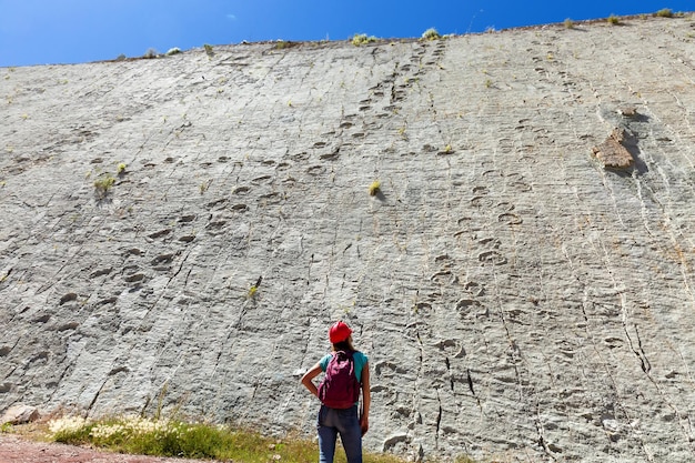 Chica turista mira las huellas fosilizadas de dinosaurios en la roca. Cal Orko .Bolivia. Sucre