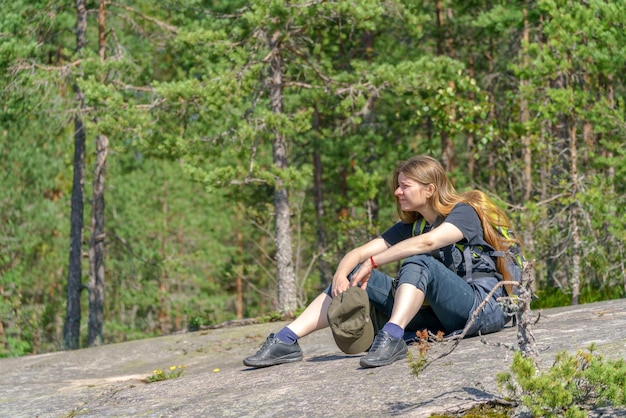 Chica turista con mochila se sienta en la orilla
