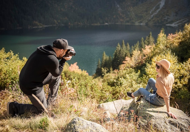 Chica turista posando para una foto en la cima de la montaña. Fotógrafo tomando fotos de una niña