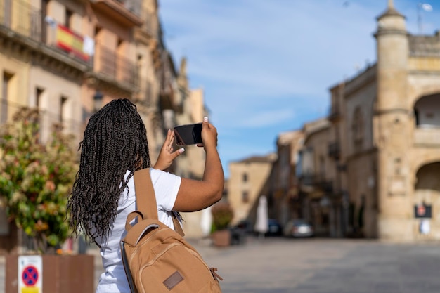 Foto chica turista de vacaciones tomando fotos con teléfono en el famoso pueblo de ciudad rodrigo en salamanca