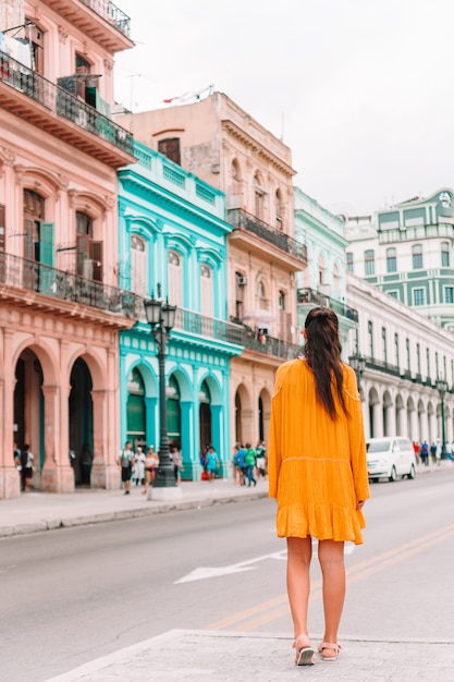 Chica turista en zona popular en La Habana, Cuba. Vista posterior del viajero joven