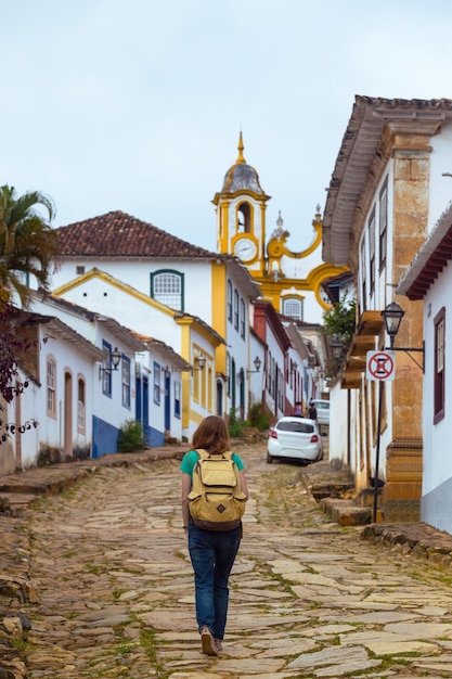 Chica turística camina por las calles de la famosa ciudad histórica de Tiradentes, Minas Gerais, Brasil