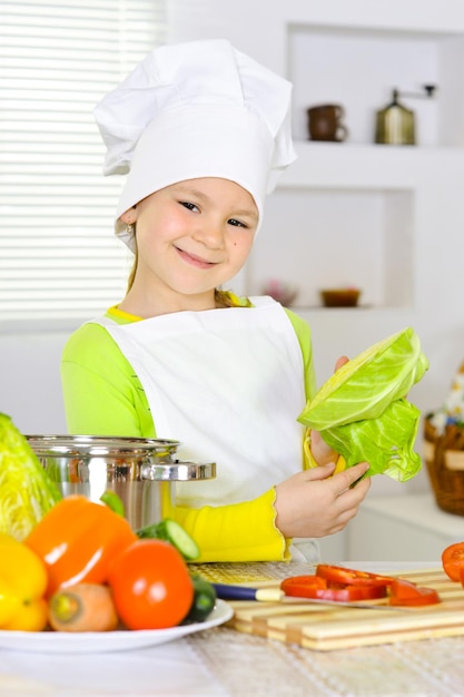 Chica con uniforme de chef cocinando