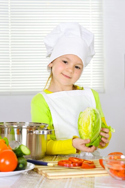 Chica con uniforme de chef cocinando