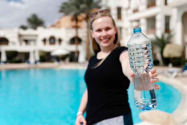 Chica con uniforme deportivo sostiene una botella de agua