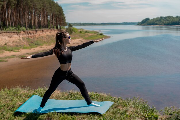 Chica en uniforme y gafas de sol haciendo deporte en un parque