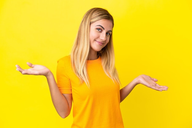 Chica uruguaya rubia aislada de fondo amarillo feliz y sonriente