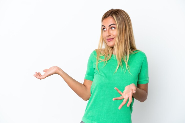 Foto chica uruguaya rubia aislada de fondo blanco con expresión de sorpresa mientras mira de lado
