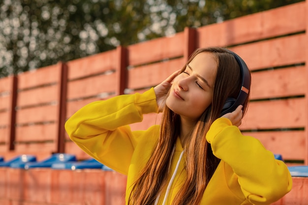 Chica usando audífonos en la calle