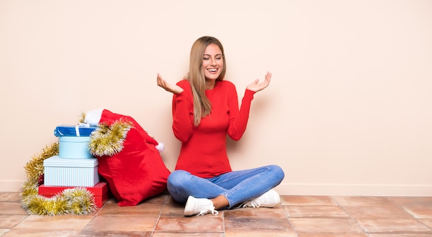 Chica en vacaciones de navidad sentados en el suelo riendo