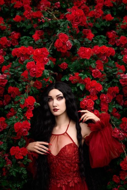 Chica vampiro sobre un fondo de rosas rojas