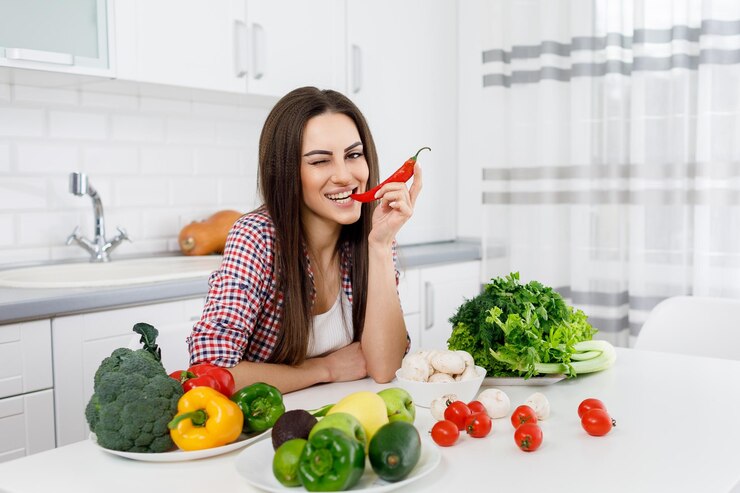 Chica vegetariana joven mordiendo un ají y guiñando un ojo