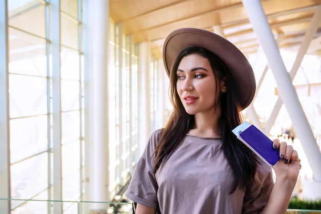 Chica en la ventana del aeropuerto espera un vuelo