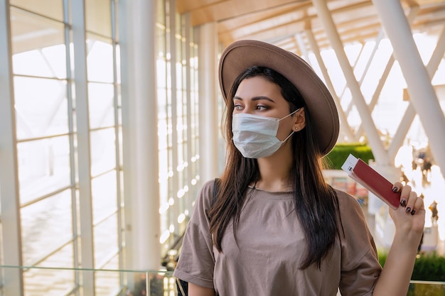 Chica en la ventana del aeropuerto espera un vuelo