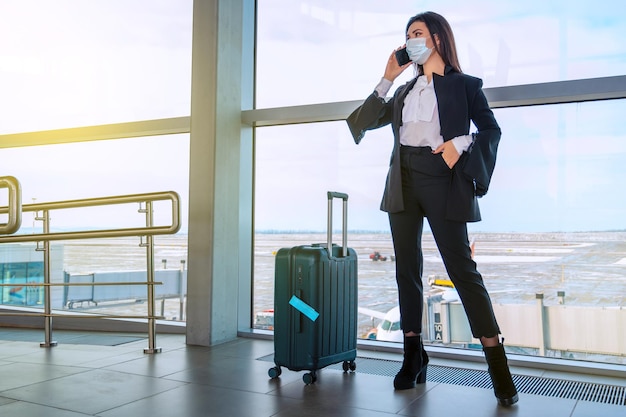 Chica en la ventana del aeropuerto espera un vuelo