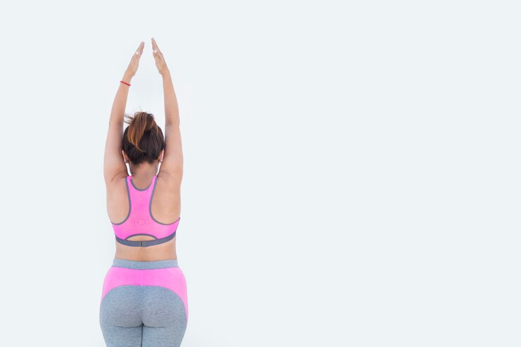 Chica vestida para practicar deporte practicando yoga