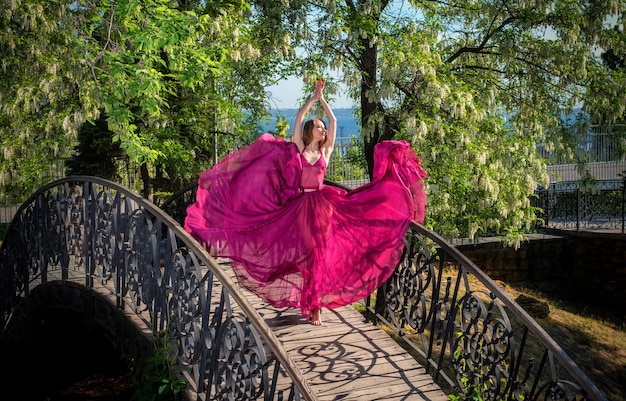 Chica en vestido aireado posando en el puente