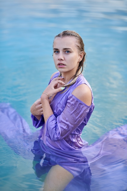 chica en vestido ajustado se baña en el lago